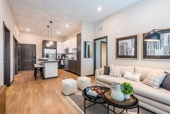 a living area with a couch coffee table and a kitchen in the background at The Livano Tryon, Charlotte, North Carolina